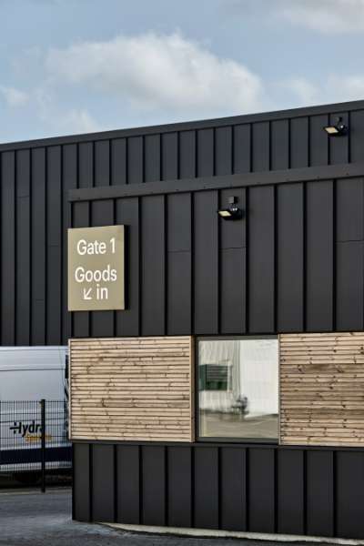 Black steel profiles and warm wood create striking contrasts on headquarters facade, Jernvej 19, 6900 Skjern, Denmark